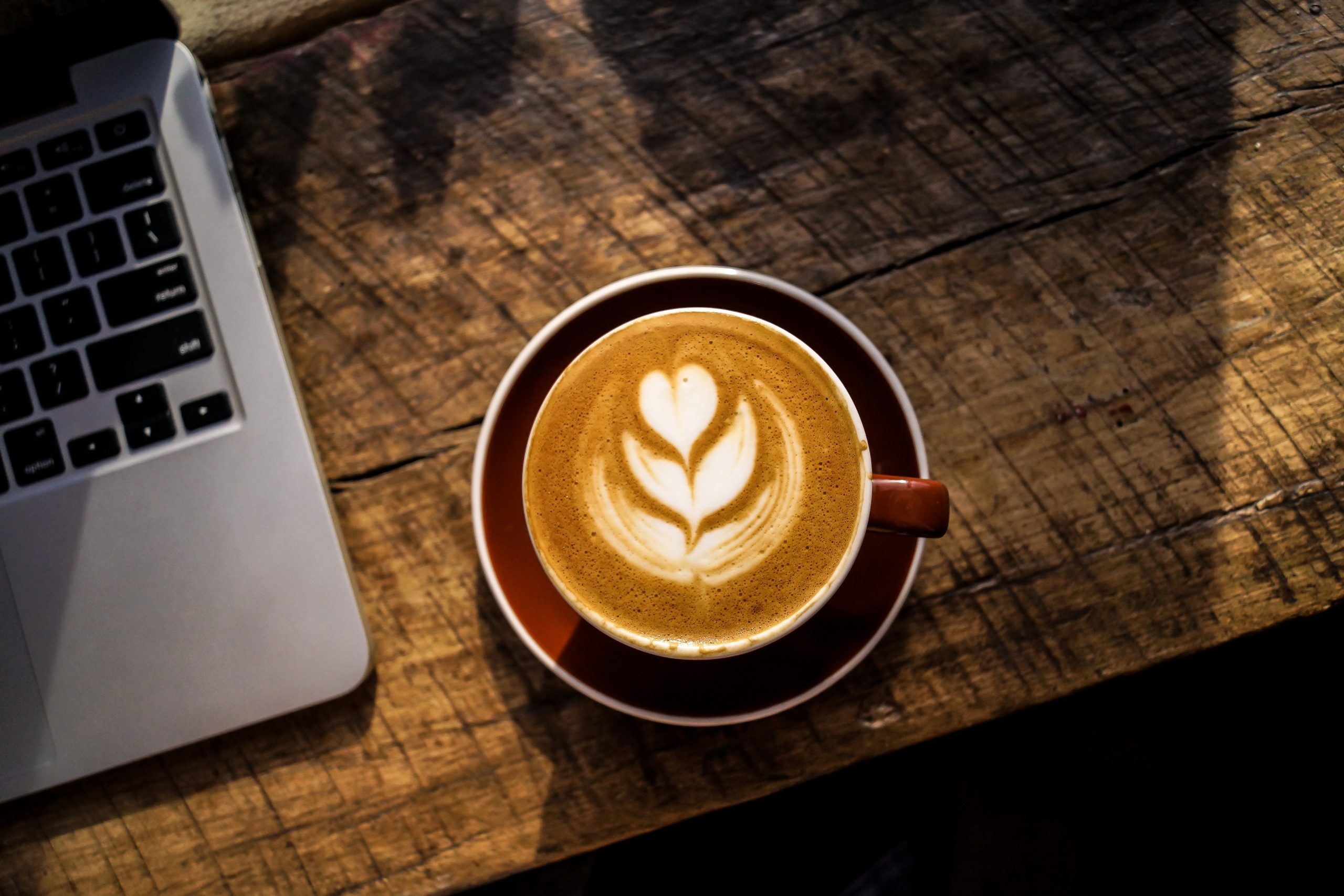 A laptop and coffee on a wooden table